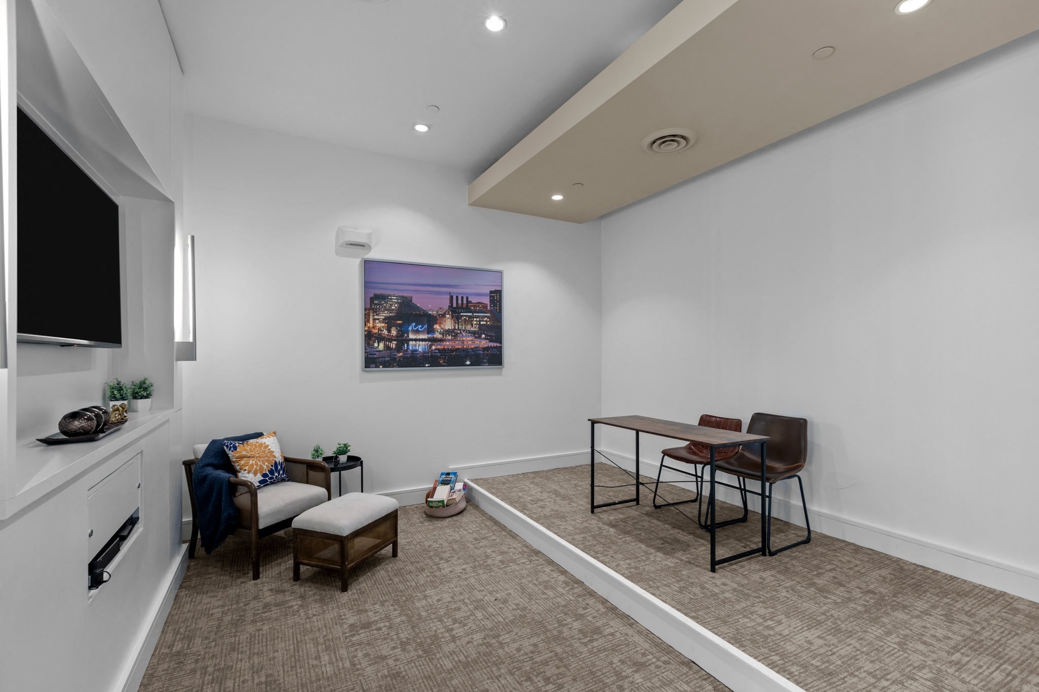 a living room with a desk and a chair and a television